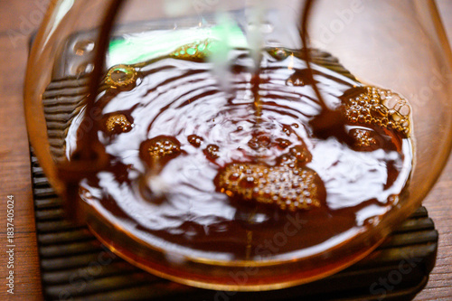 Pouring fresh hot coffee creating ripples and bubbles