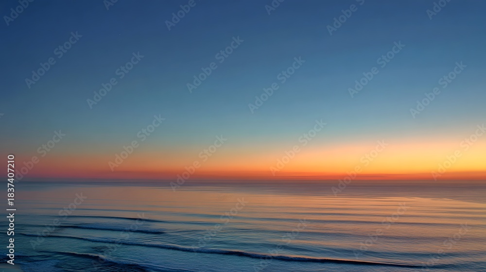 Obraz premium Horizon line perfectly divides richly colored twilight sky above serene ocean waves