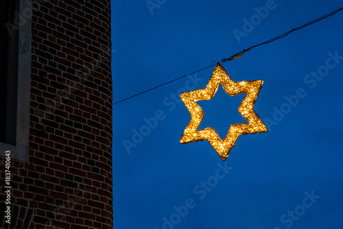 Illuminated star of david decoration hanging from wire at night