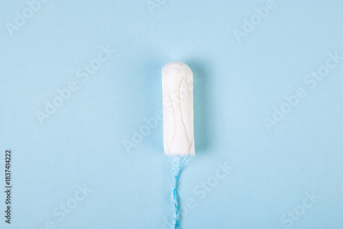 Hygienic cotton tampon on blue background. Feminine menstrual hygiene products. Womens health concept. Copy space.
