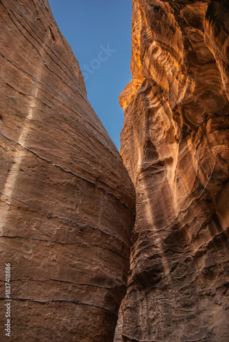 Vertical Red Sandstone Cliff with Blue Sky in Jordan. Rock Formation in Petra. Rocky Texture in the Middle East.