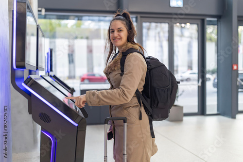 Foto Woman using self-service kiosk for digital check-in
