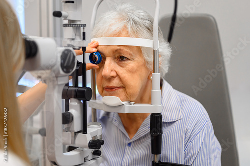 Cropped view of female ophthalmologist hand holding slit lamp for senior woman vision eye test at clinic