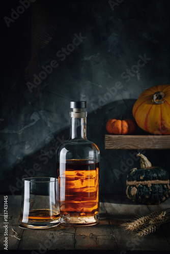 Glass and bottle of whiskey on a wooden table