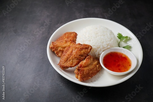 Fried chicken wings with rice and sweet chili sauce.