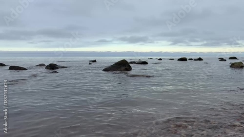 Wallpaper Mural Wide coastal seascape with dark rocks and smooth water surface under cloudy sky. Calm Baltic Sea atmosphere with soft wave sounds, filmed in 4K. Torontodigital.ca