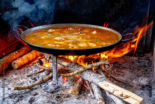 Traditional Valencian paella cooking process: boiling the broth before adding rice – Mediterranean cuisine in Spain.