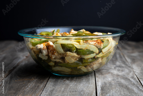 Sheet pan chicken fajitas with sliced onions, green bell peppers, and seasoned chicken arranged on a baking tray. Fresh, simple, and perfect for meal prep or easy dinner recipes.