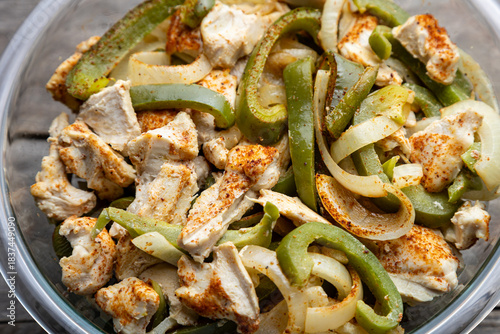 Sheet pan chicken fajitas with sliced onions, green bell peppers, and seasoned chicken arranged on a baking tray. Fresh, simple, and perfect for meal prep or easy dinner recipes.