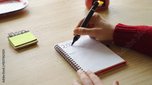 New year's resolutions. Hand writing 2026 text in notebook 