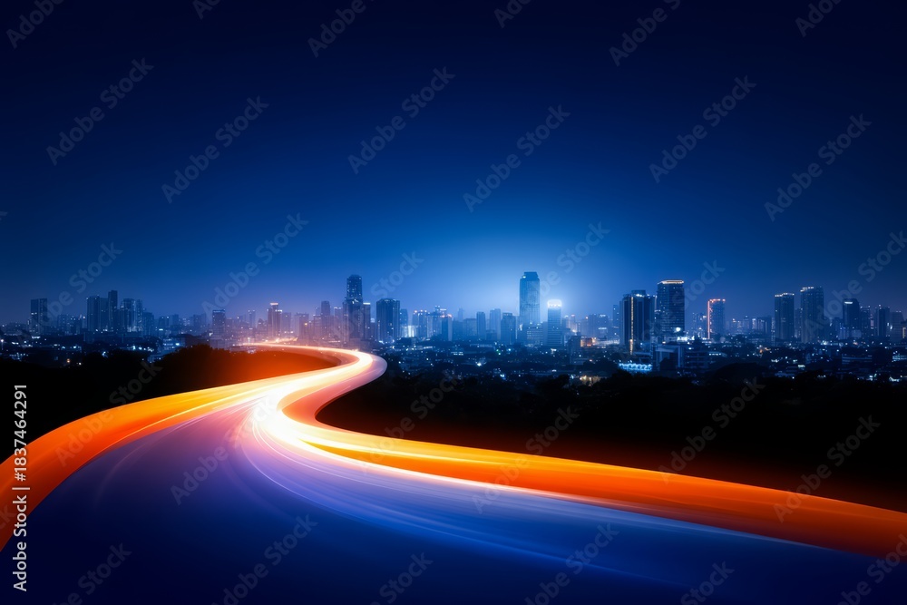 Fototapeta premium City skyline is shown with a long road that is lit up with a bright orange glow. The city appears to be at night