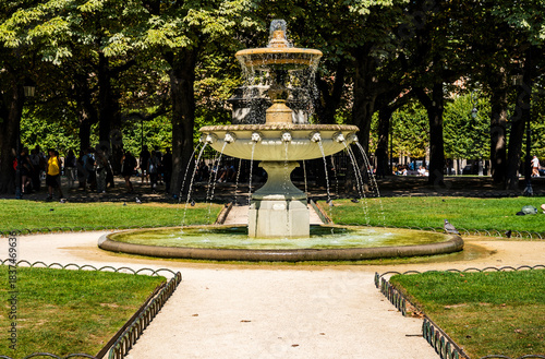 Fountain at the center Place des Vosges in the Marais district during a summer day, one of the oldest and most beautiful squares in Paris, France