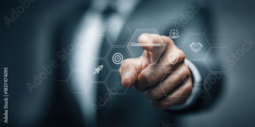 Business competences and skills development concept. Businessman pointing at virtual interface with icons representing teamwork, leadership, innovation, and goal achievement. Corporate training, emplo