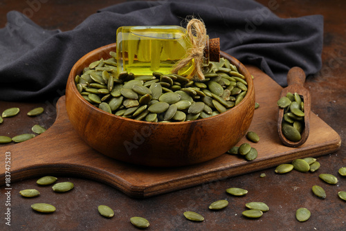 Pumpkin seeds in a wooden bowl on a wooden background