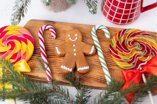 There are gingerbread men on the plate. A decorated Christmas tree and festive ornaments are in the background.