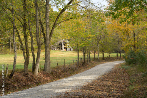 The rustic charm of an abandoned barn in Illinois beautifully highlights the vibrant colors of autumn. This picturesque barn is nestled along a winding gravel road.