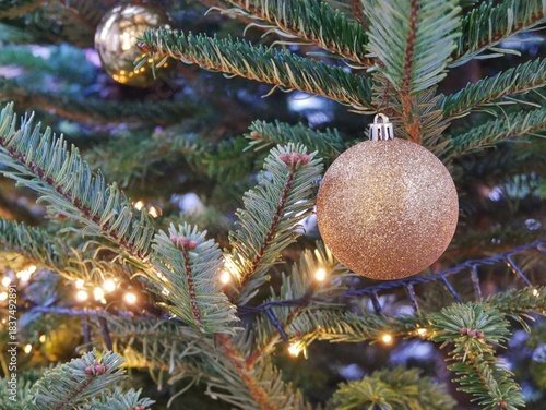 Goldene Weihnachtskugel am Tannenbaum im Freien