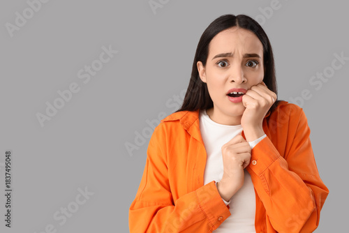 Scared young woman on light...