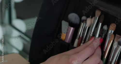 Make-up artist taking a brush from professional brush set. Beauty, makeup and fashion concept