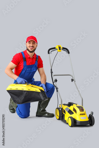 Male gardener with lawn mow...