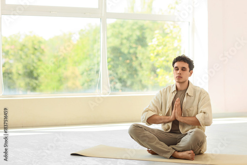 Young man meditating on yog...