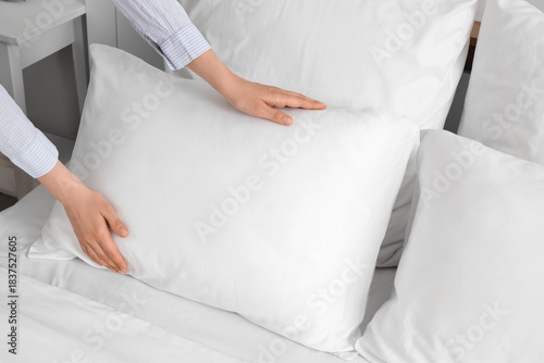 Woman adjusting white pillo...