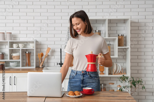 Beautiful young woman with cup of espresso, geyser coffee maker, croissants a...