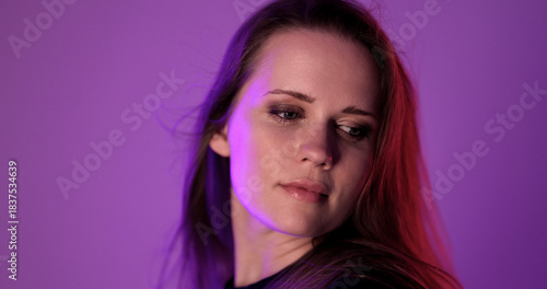 Studio portrait of a young woman with long hair and smoky eyeshadow makeup on a purple background. This image is suitable for beauty and fashion photography projects.