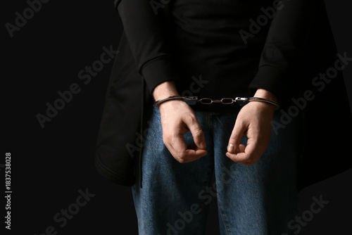 Young man in handcuffs on b...