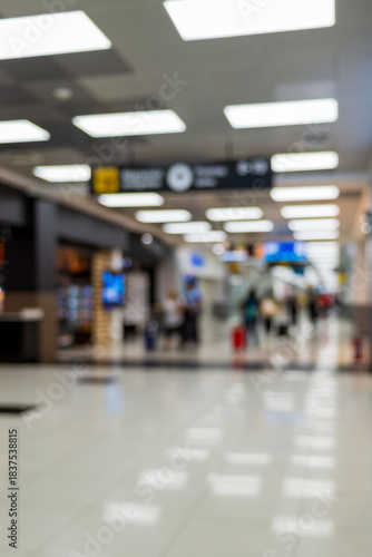 Airport terminal with people and signage. Blurred image. Background.