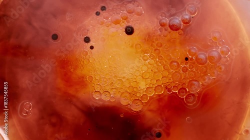 Close-up shot of thick, viscous liquid bubbling intensely in deep red and orange tones, creating the effect of boiling blood or molten organic substance. Abstract macro fluid motion with bubbles