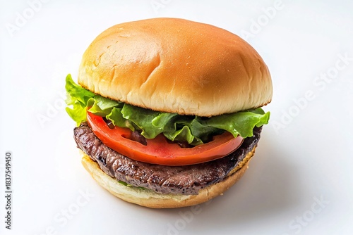 Isolated fast food hamburger or cheeseburger sandwich with beef, cheese, lettuce, tomato, and sesame seed bun on a white plate