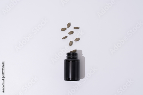 Black Plastic Supplement Bottle with Floating Pills – Minimal Healthcare Concept