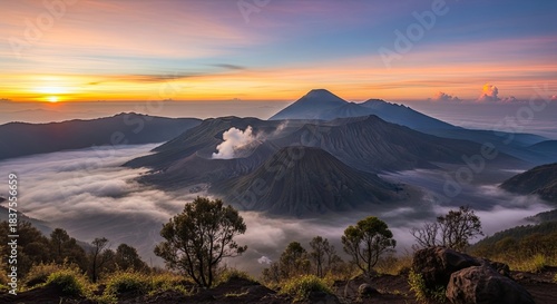 Breathtaking Sunrise Panorama of Mount Bromo Volcanic Complex with Active Smoke Rising Above a Sea of Clouds in Indonesia