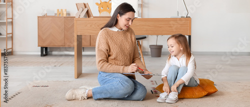 Female psychologist with clipboard and little girl in office