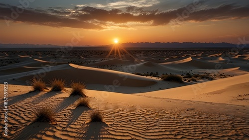 Sunset over a vast desert with sand dunes