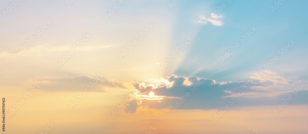 Obraz premium Beautiful cloudscape with sun rays and orange evening light at sea sunset