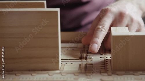 Hands of Adult Man Building Architecture Model Close Up. Caucasian Person Constructs City Landscape and Makes Roads with Little Cars. Builder Crafts Wood Miniatures of Future People Life in New Style