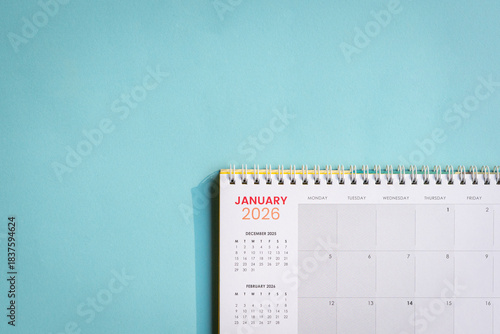 January 2026 Calendar lying flat on top of light blue paper surface. Copy space.