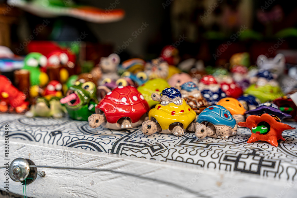 Fototapeta premium Handmade colorful ceramic turtle crafts displayed on a market table in Peru, with vibrant designs and playful artisan details.