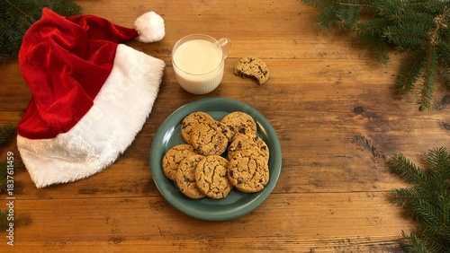 Oat milk and cookies on rustic table with Santa hat, Christmas setting