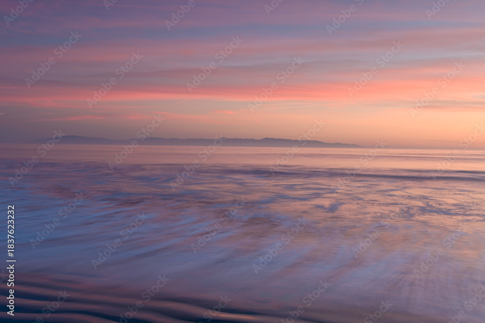 Obraz premium Soft pastel colors of ocean waves of the Pacific Ocean, as the sun sets over the Monterey Bay, Santa Cruz, California 