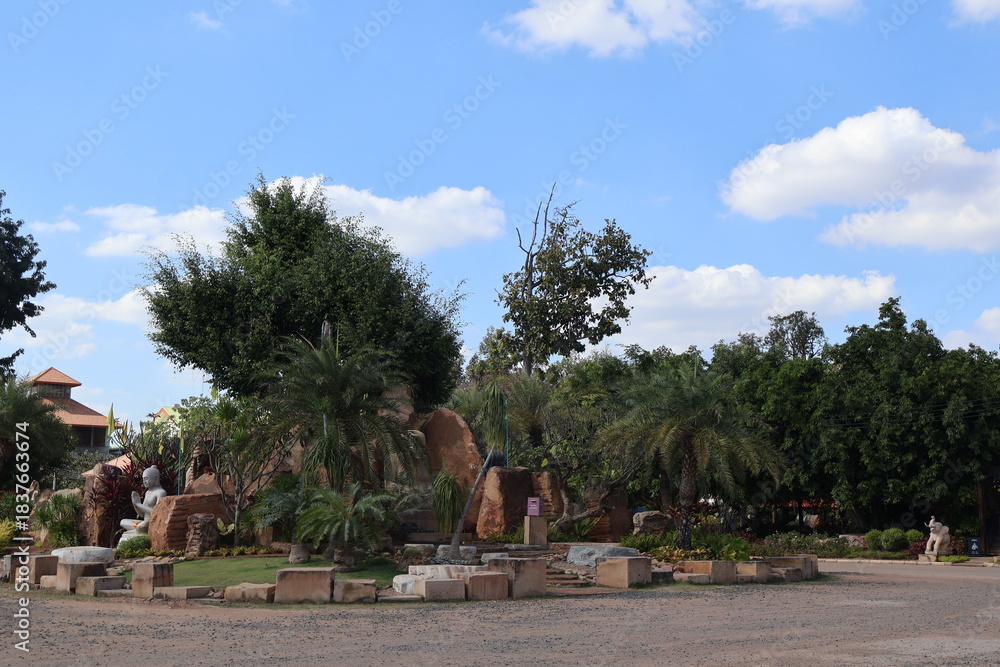 Fototapeta premium An outdoor recreational area under a clear sky. In the center of the frame is a focal point with a palm tree that's been creatively repurposed into a decorative item for a playground