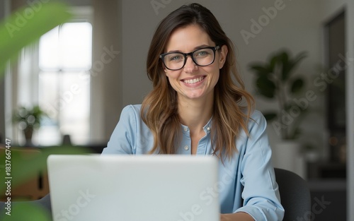 An attractive middle aged businesswoman sitting in front of laptop and managing her small business from home. High quality