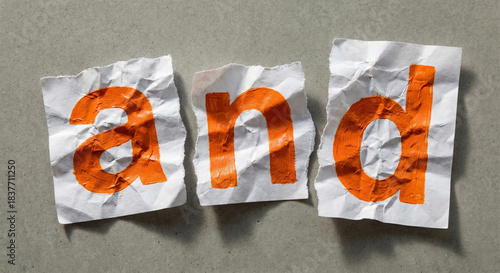 The word AND spelled out on crumpled white paper texture