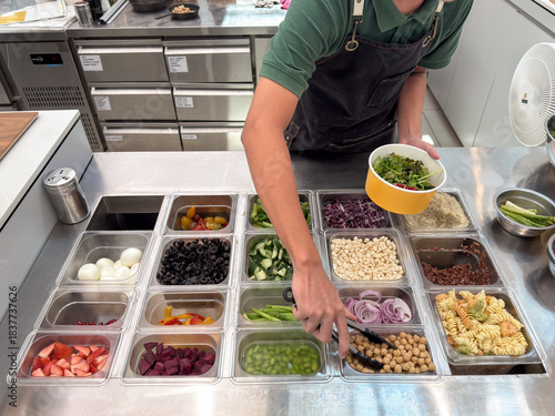Salad preparation with various ingredients in fresh cafe kitchen setting