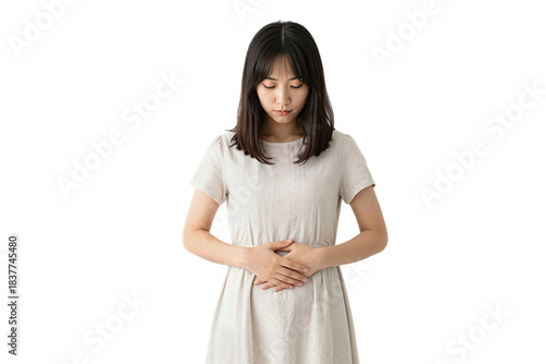 Asian woman in white dress holding her belly with eyes closed