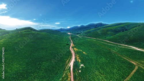 Aerial View of Winding Road Through Rolling Green Mountains and Valley