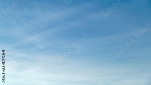 Clear blue sky with soft white clouds, time lapse. Bright blue sky with gentle white clouds creating a calm and peaceful atmosphere, perfect for backgrounds, design projects, and relaxation themes.