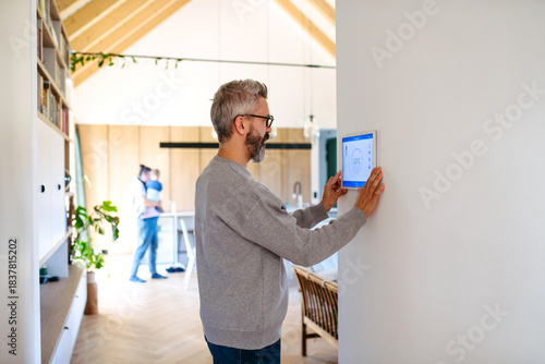 Bild auf Leinwand Man using smart home control panel.